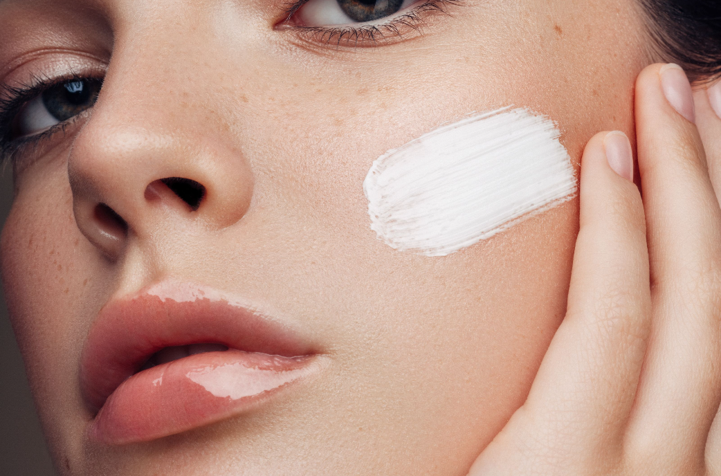 Woman applying cream on her face